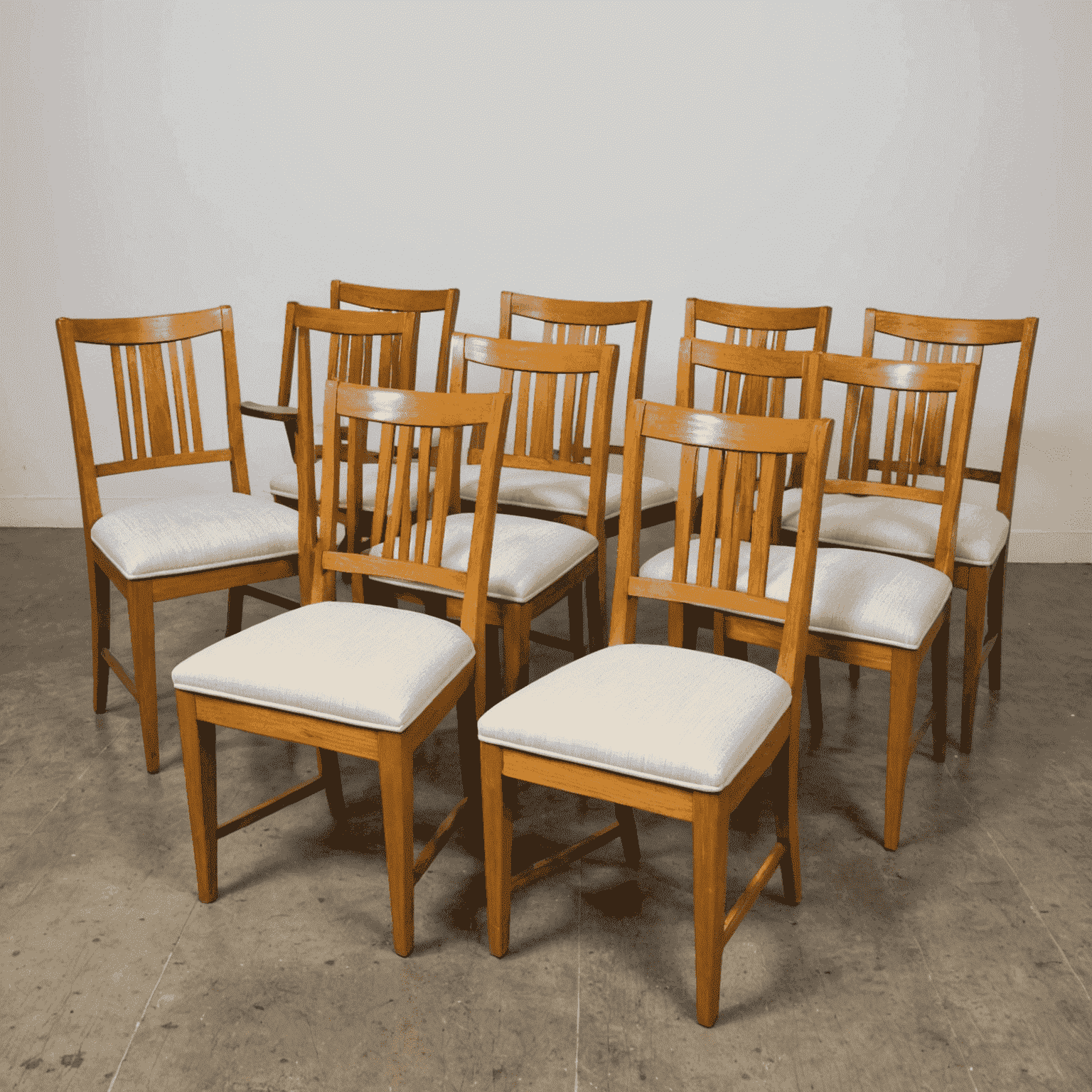 A set of six dining chairs with newly upholstered seats in a contemporary geometric pattern. The wooden frames have been refinished in a light oak color, bringing a fresh, modern look to the traditional chair design.